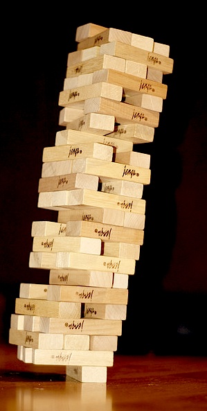 IMAGE A Jenga tower miraculously leans and balances on a single, uncentered, block. IMAGE