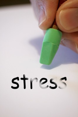 IMAGE A person uses a green pencil eraser to rub out the word stress. IMAGE