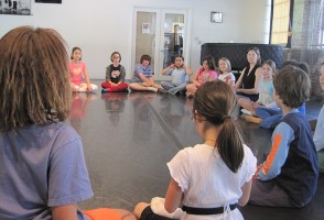 [image] Children sit in a circle at Hope Center's dance studio [image]