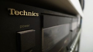 IMAGE Close visual of the power button and cassette deck of a Technics music stereo component. IMAGE