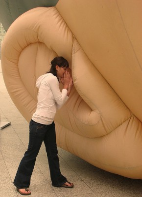 IMAGE A woman whispers into a large ear sculpture in The Hague. IMAGE