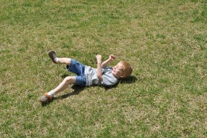IMAGE Child rolling in the grass. IMAGE