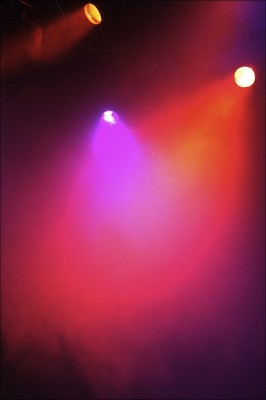IMAGE Colorful spotlights illuminate a foggy stage. IMAGE