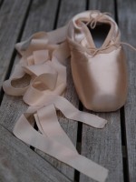 New pointe shoes with ribbons curling beside